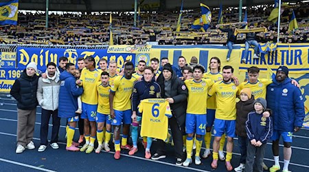 Jubel mit Flick-Trikot: Die Spieler von Eintracht Braunschweig grüßen nach dem 2:0-Sieg gegen Kaiserslautern ihren verletzten Mitspieler. / Foto: Swen Pförtner/dpa