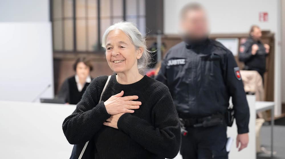 Die Angeklagte Daniela Klette reagiert zu Beginn des Verhandlungstages auf Unterstützer im Zuschauerbereich und Geburtstagslied.  / Foto: Sina Schuldt/dpa