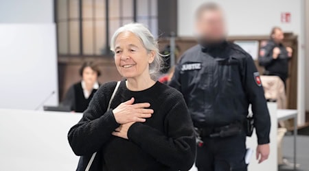 Die Angeklagte Daniela Klette reagiert zu Beginn des Verhandlungstages auf Unterstützer im Zuschauerbereich und Geburtstagslied.  / Foto: Sina Schuldt/dpa