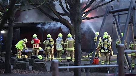 Bis in die Nacht löschen Feuerwehrleute die Flammen in der Grundschule.  / Foto: FrM/dpa