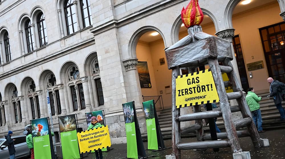 Vor dem Umweltministerium machen Greenpeace-Aktivisten mit einem Bohrturm-Protest auf die umstrittene Gasförderung vor Borkum aufmerksam. / Foto: Shireen Broszies/dpa