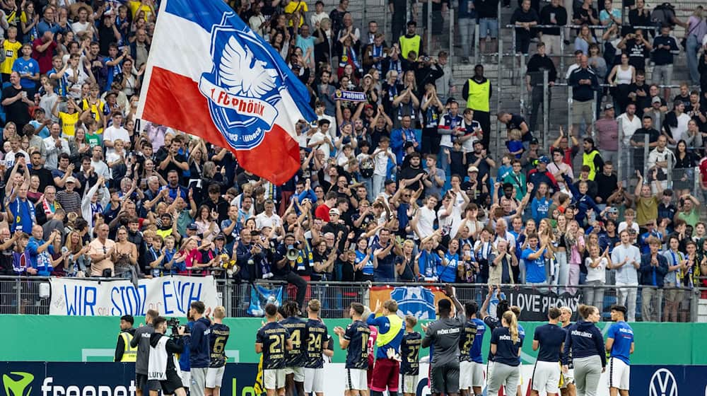 Fans des 1. FC Phönix Lübeck - hier beim Pokalspiel 2024 gegen Borussia Dortmund im Hamburger Volksparkstadion. (Archivbild)   / Foto: Axel Heimken/dpa