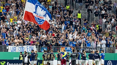 Fans des 1. FC Phönix Lübeck - hier beim Pokalspiel 2024 gegen Borussia Dortmund im Hamburger Volksparkstadion. (Archivbild)   / Foto: Axel Heimken/dpa