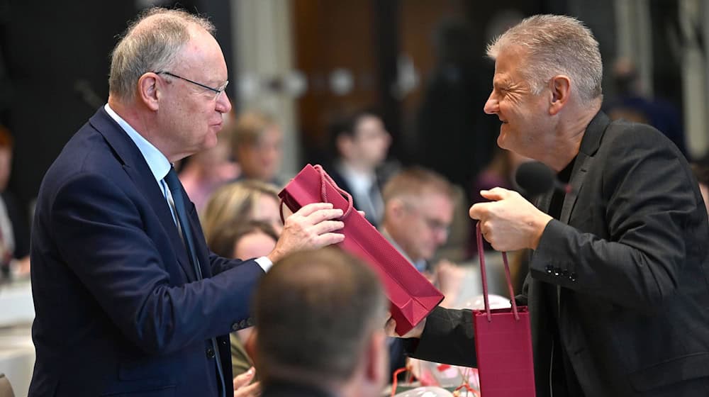Geburtstagsgruß im Parlament: SPD-Fraktionschef Politze (r) überreicht Ex-Ministerpräsident Weil (l) eine Flasche Wein. / Foto: Shireen Broszies/dpa
