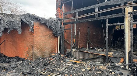 Vor der zerstörten Aula zeigt sich das Ausmaß des Brandes deutlich. / Foto: Kilian Genius/dpa