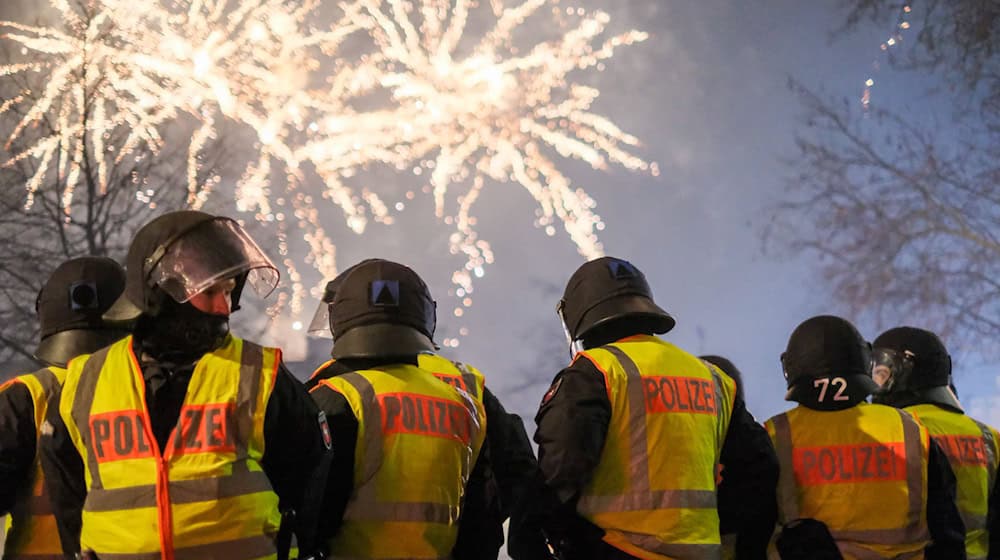 Polizeikräfte sichern den Jahreswechsel – Silvester ist für viele ein Fest, für andere Arbeit. (Archivbild) / Foto: Clemens Heidrich/dpa