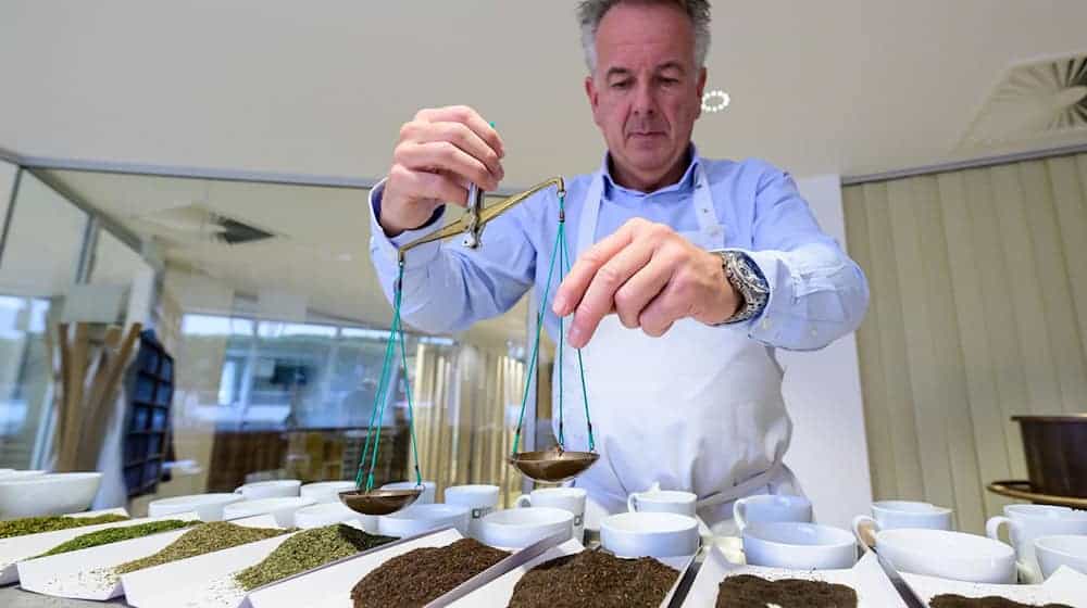 Teetester Stefan Feldbusch bereitet eine Verkostung vor und wiegt den Tee ab. / Foto: Philipp Schulze/dpa