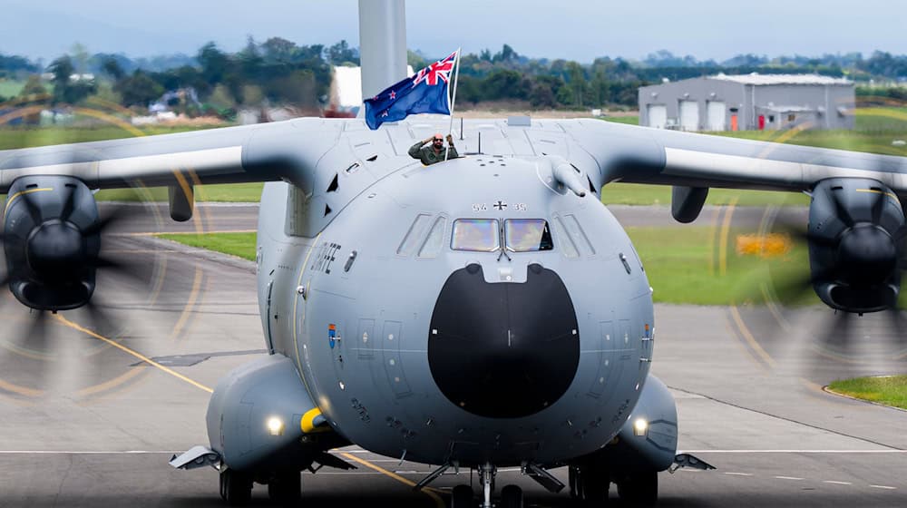 Ein Soldat der Luftwaffe zeigt bei der Landung die neuseeländische Flagge. (Handout) / Foto: Connor Williams/New Zealand Defence Force/dpa