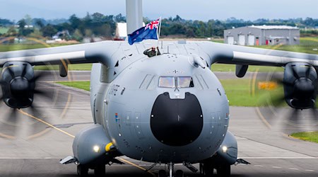 Ein Soldat der Luftwaffe zeigt bei der Landung die neuseeländische Flagge. (Handout) / Foto: Connor Williams/New Zealand Defence Force/dpa