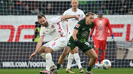 Wolfsburgs Lovro Majer (r) wird vom Heidenheimer Benedikt Gimber bedrängt. / Foto: Swen Pförtner/dpa