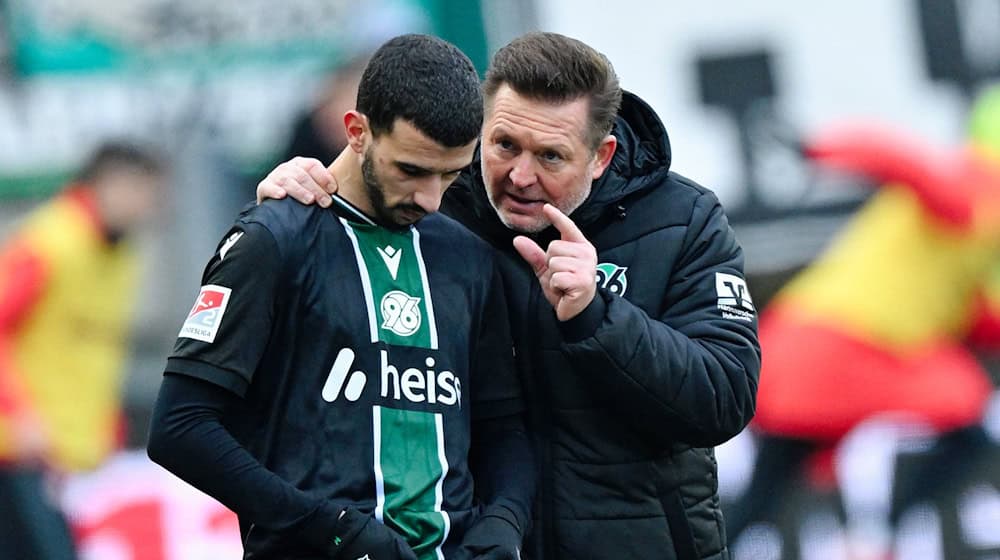 Trainer Christian Titz (r, Hannover 96) spricht bei der Einwechslung mit Waniss Taïbi (Hannover 96).  / Foto: Uwe Anspach/dpa