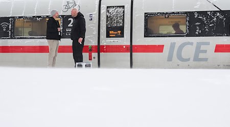 Gute Laune trotz unfreiwilligen Stopps auf dem Weg nach Freiburg: Zwei HSV-Fans auf dem Bahnsteig in Hannover. / Foto: Julian Stratenschulte/dpa