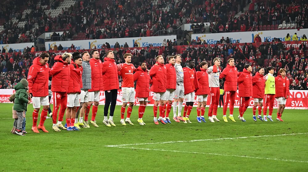 Die Mainzer feiern mit den Fans einen Sieg - wenig später wird das Stadion geäumt.  / Foto: Torsten Silz/dpa