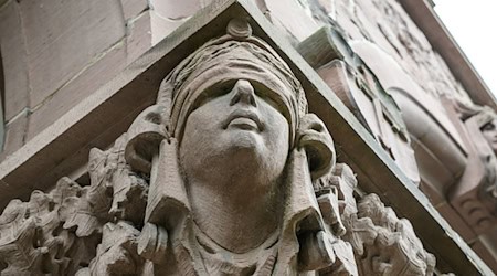 Ein Mann stirbt unerwartet im Amtsgericht Oldenburg. Eine Skulptur der Justitia hängt an einer Säule an dessen Eingang. (Symbolbild) / Foto: Izabela Mittwollen/dpa