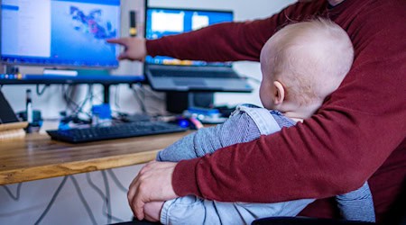 Sicher nicht ganz einfach: Ein junger Vater arbeitet im Homeoffice mit seinem Sohn. (Symbolbild) / Foto: Jens Büttner/dpa