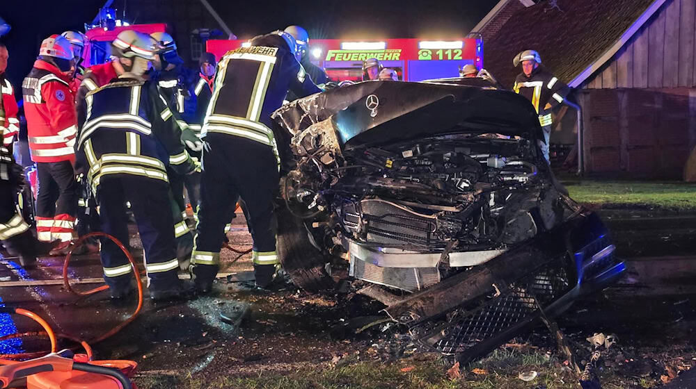 Einsatzkräfte am stark beschädigten Unfallfahrzeug im Landkreis Osnabrück. / Foto: -/NWM-TV/dpa