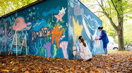 Kinder aus der Nachbarschaft gestalten gemeinsam eine bunte Unterwasserwelt mitten im Quartier Dodesheide. Bildnachweis: Vonovia / Bierwald