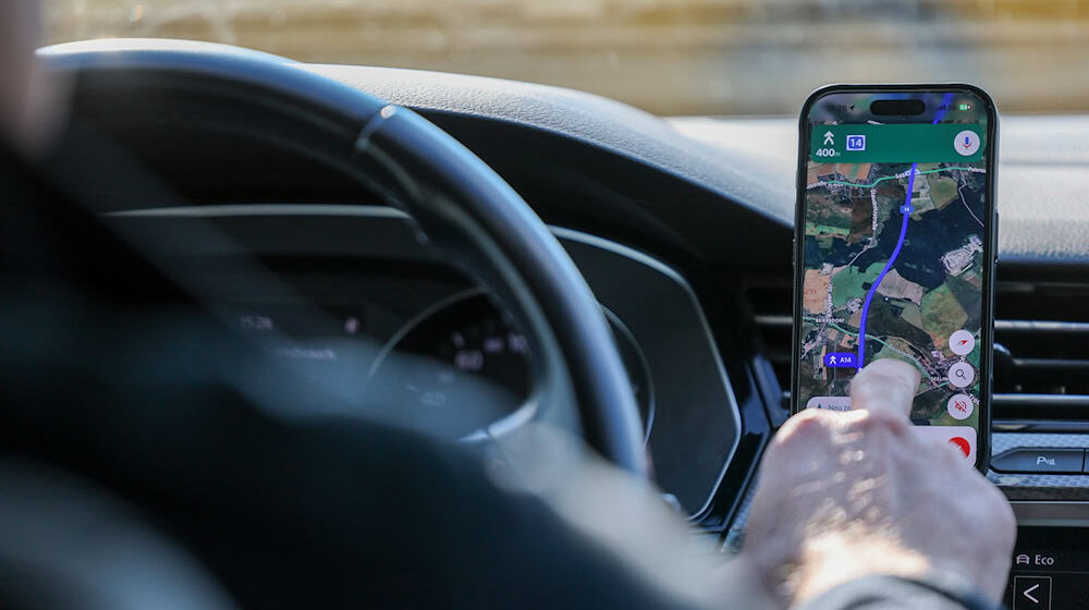 So ist es derzeit erlaubt: Das Handy steckt in der Halterung und wird nur kurz vom Fahrer beachtet. (Symbolbild) / Foto: Jan Woitas/dpa