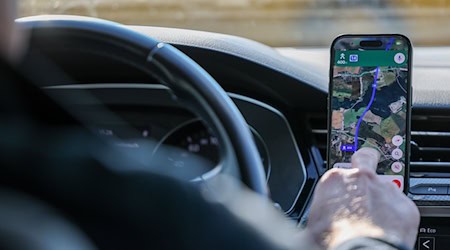 So ist es derzeit erlaubt: Das Handy steckt in der Halterung und wird nur kurz vom Fahrer beachtet. (Symbolbild) / Foto: Jan Woitas/dpa