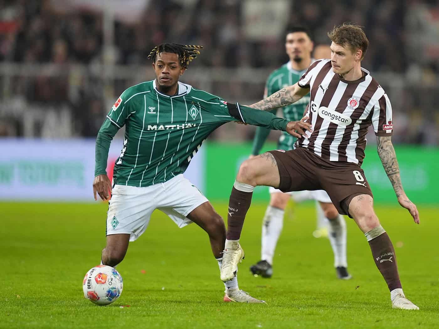 Eric Smith (r, FC St. Pauli) und Samuel Mbangula (Werder Bremen) kämpfen um den Ball. (Archivbild) / Foto: Marcus Brandt/dpa