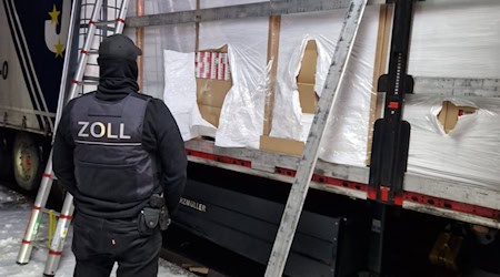 Ein Zöllner steht vor einem mit Zigaretten beladenem Lkw. / Foto: Zoll Hannover/dpa