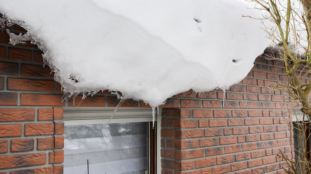 Wenn vor allem bei Tauwetter Schnee und Eis vom Dach rutschen, ist das nicht nur gefährlich, sondern kann auch teuer werden. Denn für Schäden durch Dachlawinen haften in vielen Fällen die Hausbesitzer. / Foto: Julian Stratenschulte/dpa