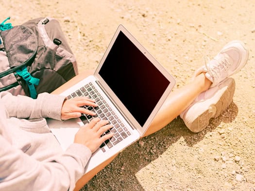 Person arbeitet entspannt mit Laptop im Freien – digitale Autonomie und Flexibilität als moderner All-Rounder.