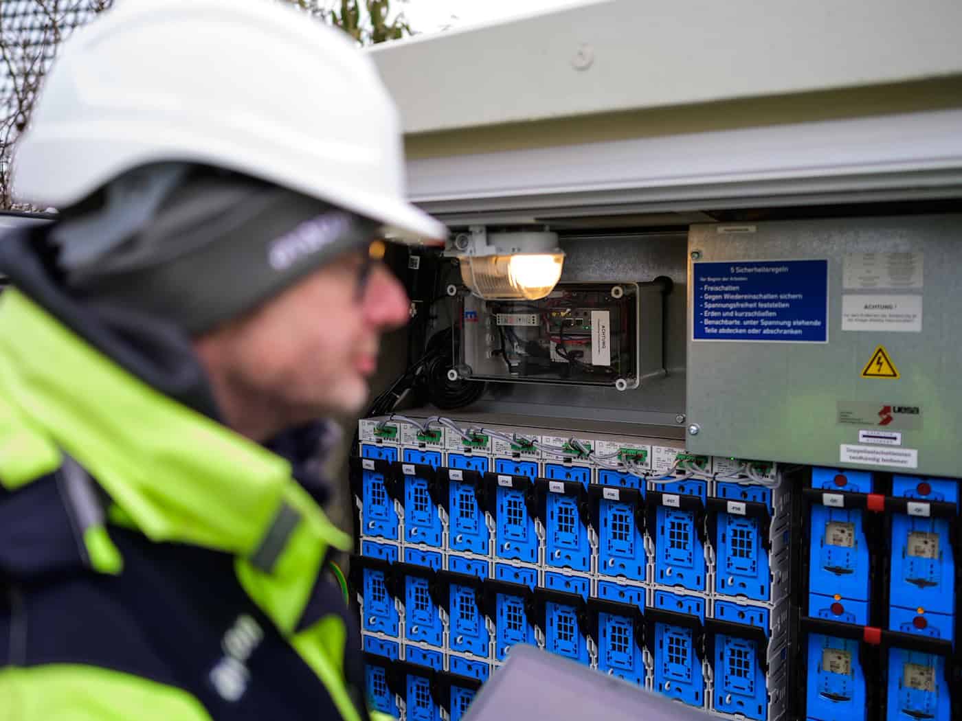 Andreas Formann, Mitarbeiter der Avacon Netz GmbH, blickt in eine Ortsnetzstation, die bereits digitalisiert wurde. / Foto: Philipp Schulze/dpa