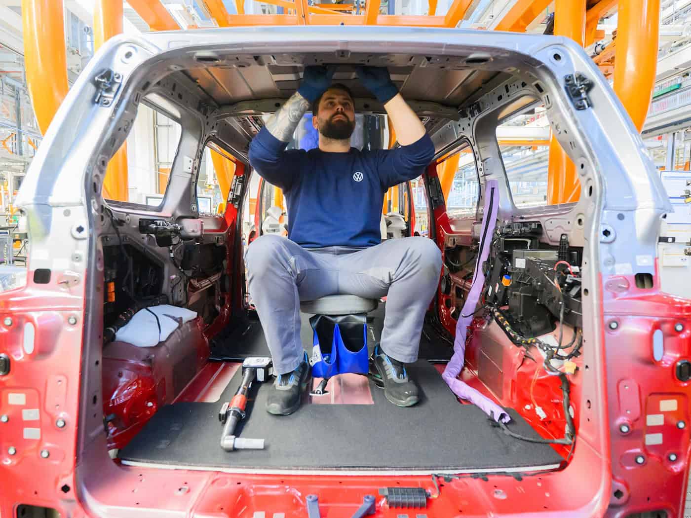 Ein Mitarbeiter montiert einen Elektro-Bulli ID. Buzz im Werk von Volkswagen Nutzfahrzeuge.  / Foto: Julian Stratenschulte/dpa