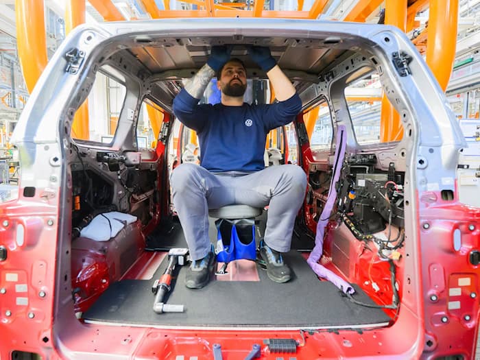 Ein Mitarbeiter montiert einen Elektro-Bulli ID. Buzz im Werk von Volkswagen Nutzfahrzeuge.  / Foto: Julian Stratenschulte/dpa