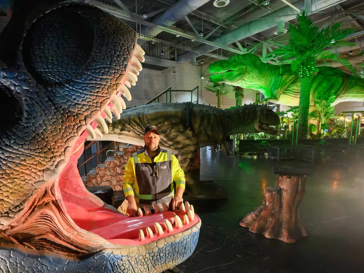 Inhaber Christopher Richter steht zwischen Dinosaurier-Modellen in seiner Ausstellung «Königreich der Dinosaurier» in der Messe Hannover. / Foto: Julian Stratenschulte/dpa