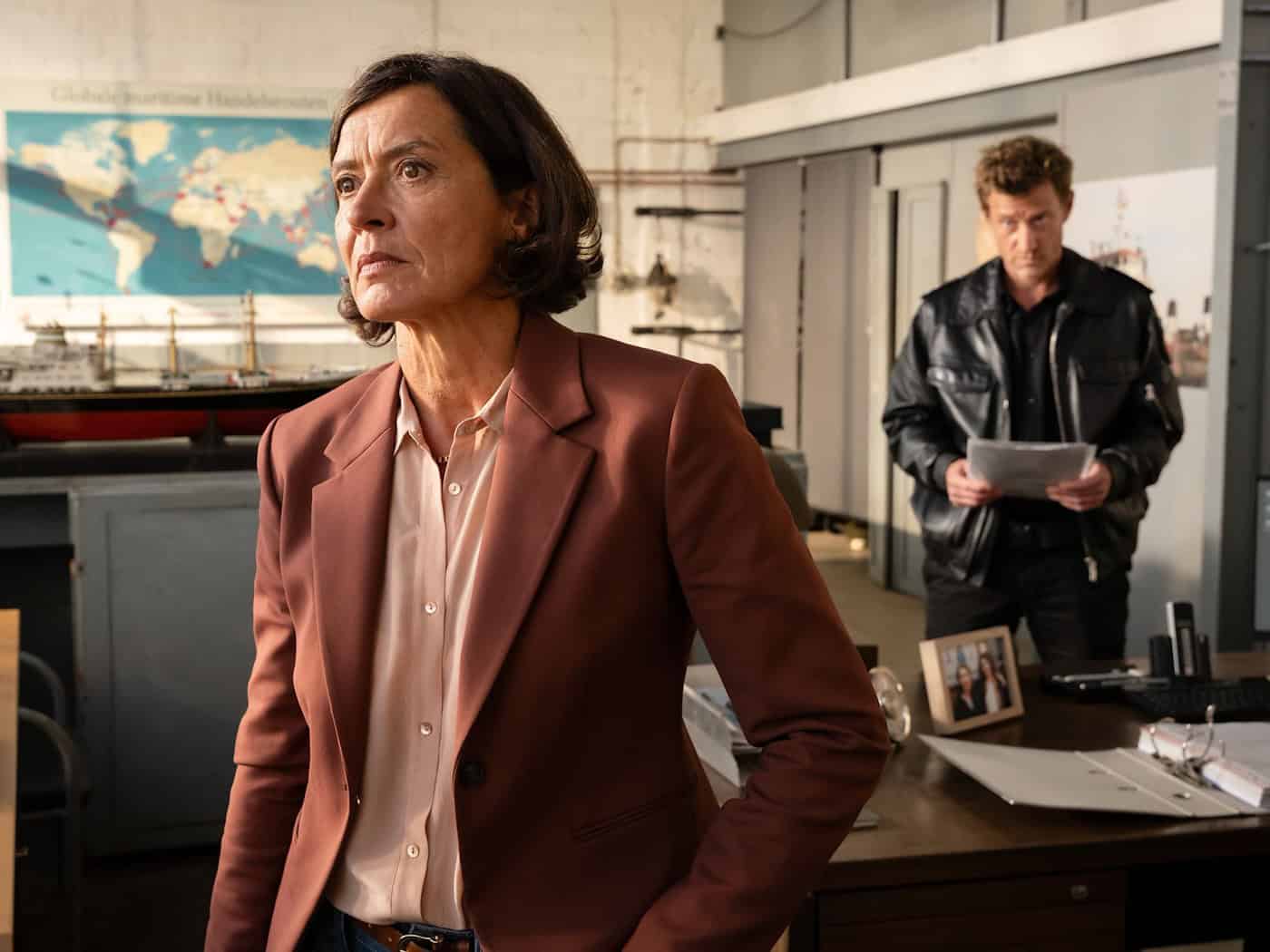 Reederei-Chefin Amke Wilhelmson (Ulrike Folkerts) wird von Henk Cassens (Maxim Mehmet) befragt - Szene aus dem ZDF-Krimi «Friesland - Schiffe schrotten» (schon im Streamingportal, am 11.3. im Fernsehen). / Foto: Michael Kötschau/ZDF/dpa