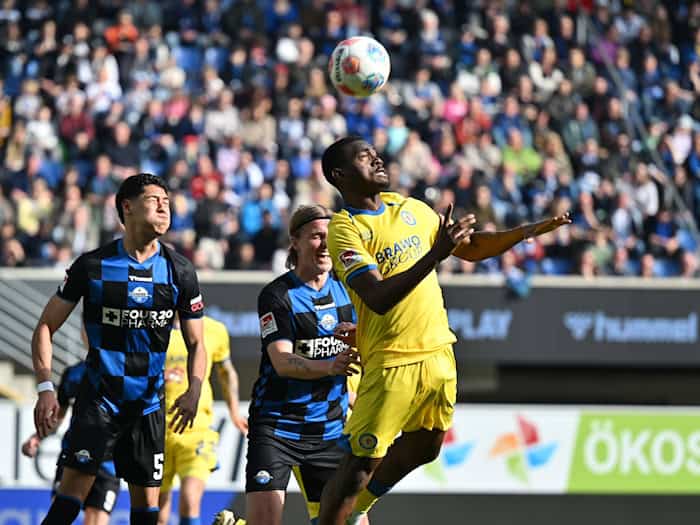 Braunschweigs Patrick Nkoa ist eher am Ball als die beiden Paderborner Santiago Castaneda (l) und Felix Götze. / Foto: Swen Pförtner/dpa
