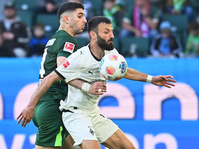 Im Zweikampf: Gladbachs Franck Honorat (r) wird vom Wolfsburger Konstantinos Koulierakis bedrängt. / Foto: Swen Pförtner/dpa