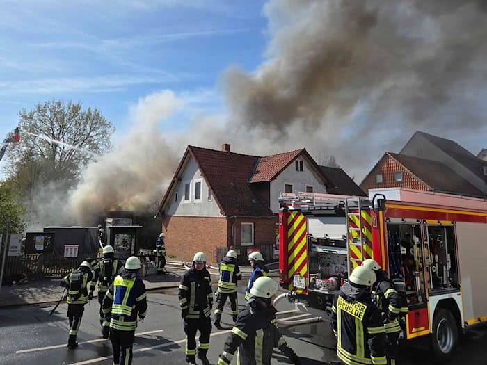 Dichter Rauch steigt über einem Wohngebiet in Vechelde auf, während Einsatzkräfte gegen die Flammen kämpfen. / Foto: Christian Brahmann/dpa