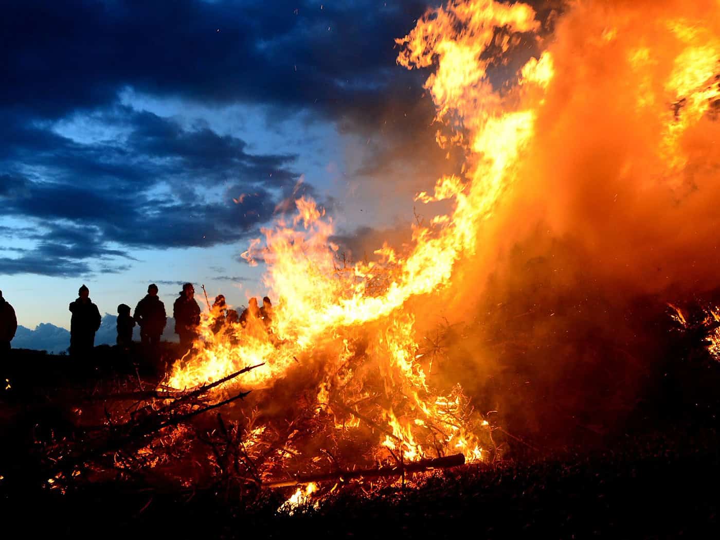 Ein Osterfeuer lodert in der Dämmerung: Der traditionelle Brauch steht zwischen geselligem Frühlingsevent und der Kritik von Natur- und Tierschützern. (Symbolbild) / Foto: Maurizio Gambarini/dpa