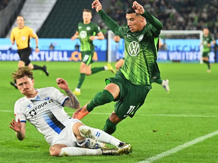 Hartnäckiger Außenseiter: Paderborns Calvin Brackelmann (l) stoppt den Wolfsburger Adam Daghim im Relegations-Hinspiel. / Foto: Swen Pförtner/dpa