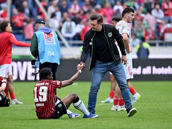 Große Enttäuschung: Hannovers Trainer Christian Titz hilft seinem Spieler William Kokolo nach dem verpassten Aufstieg wieder auf die Beine. / Foto: Swen Pförtner/dpa