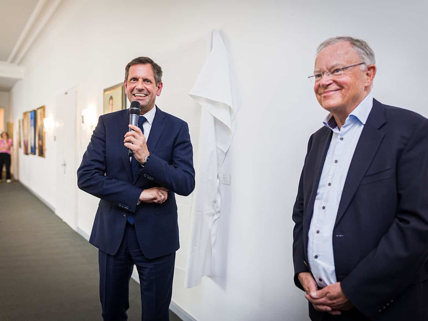 Ministerpräsident Olaf Lies (SPD, links) und dessen direkter Vorgänger Stephan Weil (auch SPD) stehen vor der Enthüllung des Porträts von Weil in der Niedersächsischen Staatskanzlei. / Foto: Moritz Frankenberg/dpa