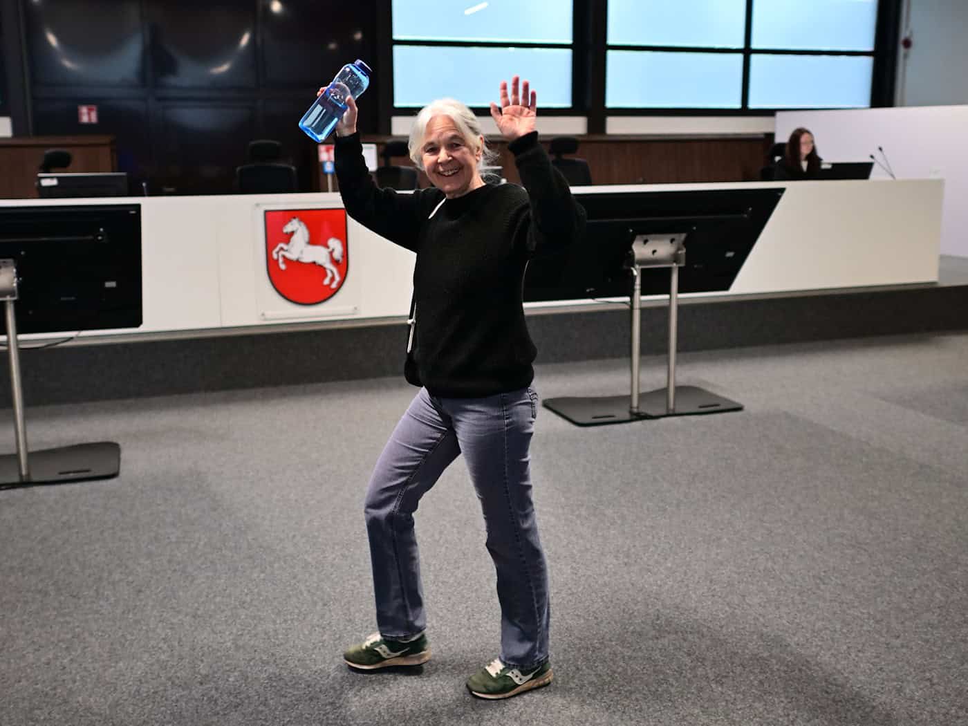 Daniela Klette winkt freudig, wenn Unterstützer im Publikum sitzen. (Archivbild) / Foto: Sina Schuldt/dpa