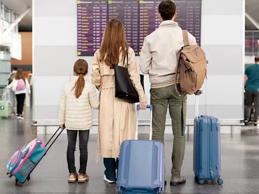 Familie mit Koffer am Flughafen – Symbol für Flugverspätungen und Reiserechte.