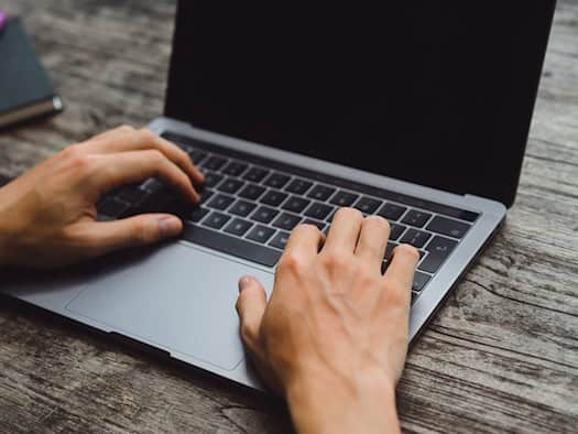 Hände tippen auf Laptop-Tastatur – Symbol für digitale PDF-Übersetzung und internationale Kommunikation.
