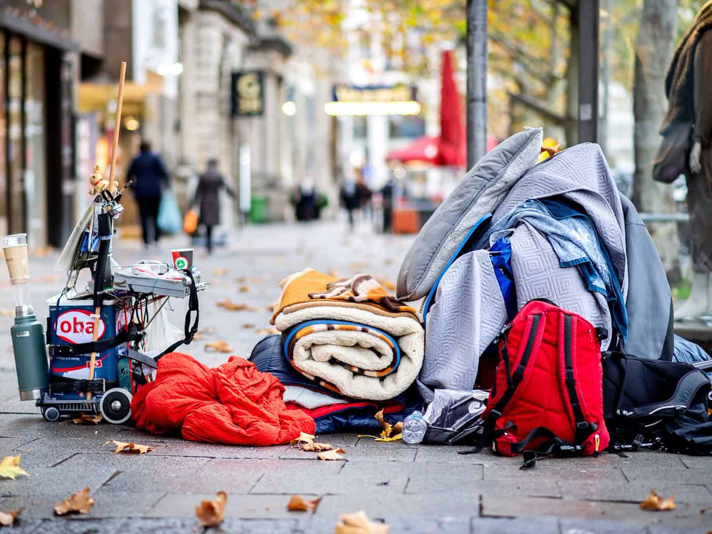 Die Habseligkeiten eines Obdachlosen liegen auf einem Bürgersteig in der Innenstadt Hannovers. Nicht nur kalte Winter sind für wohnungslose Menschen eine Gefahr, sondern auch heiße Sommer. (Archivbild) / Foto: Hauke-Christian Dittrich/dpa