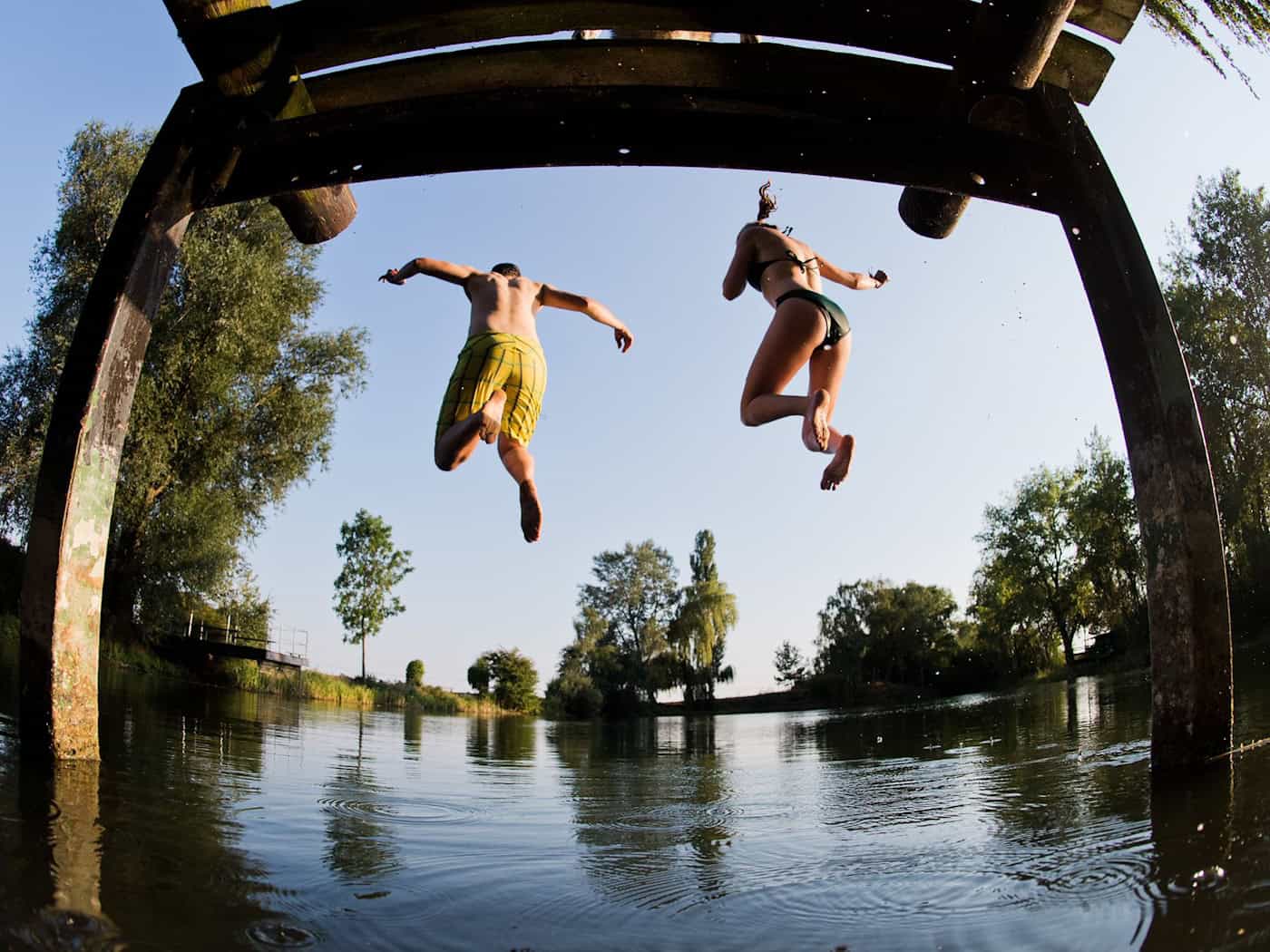 Beim Baden ist Vorsicht wichtig - hier springen zwei Menschen in einen See in Hannover. (Symbolbild) / Foto: Julian Stratenschulte/dpa/dpa-tmn