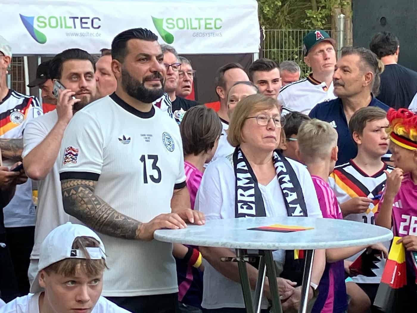 Zwei aus Undavs Heimat, die den WM-Star schon lange kennen: : Edeltraut Koch (M), Undavs erste Trainerin, und Aykut Kaldirici (l), Freund der Familie und Trainer der 1. Herren des TSV Achim. / Foto: Claas Henning/dpa