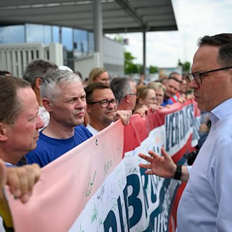 Sachsens Wirtschaftsminister Dirk Panter (SPD) spricht mit Mitarbeitern von Volkswagen in Zwickau über die aktuelle Lage. / Foto: Hendrik Schmidt/dpa