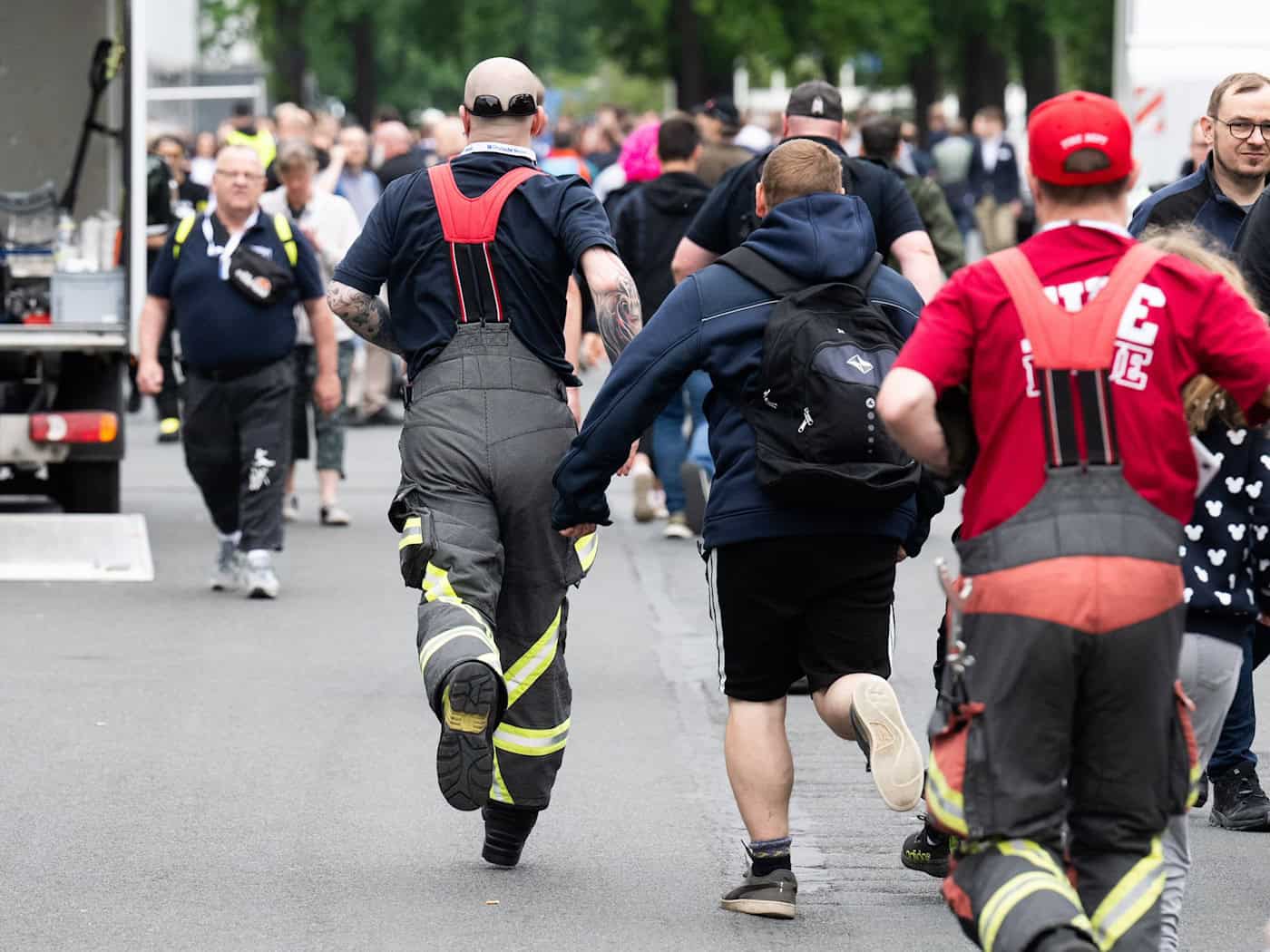 Besucher rennen zu Messebeginn auf der Messe Interschutz, um in Halle 15 einen von 1.000 kostenlosen Rucksäcken am Stand von Haix zu ergattern. / Foto: Julian Stratenschulte/dpa