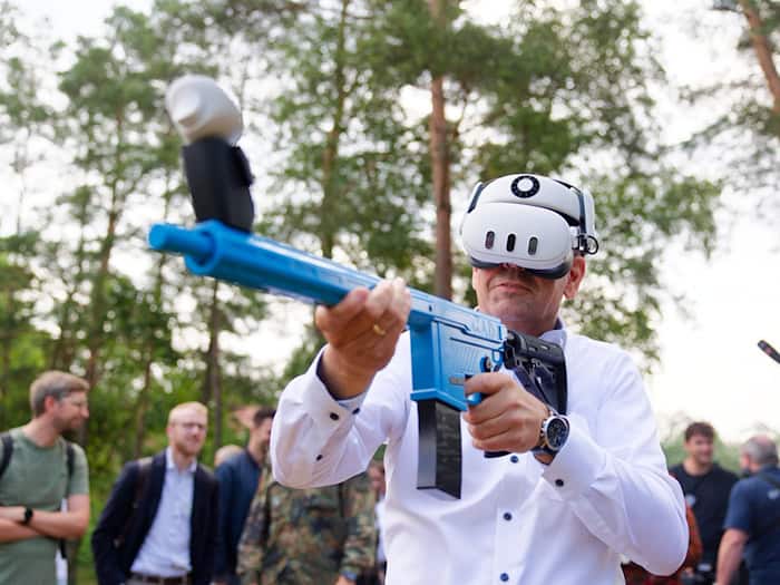 Mit einem Übungsgewehr und einer Virtual-Reality-Brille übt Regierungschef Lies virtuell den Abschuss feindlicher Drohnen. / Foto: Michael Matthey/dpa