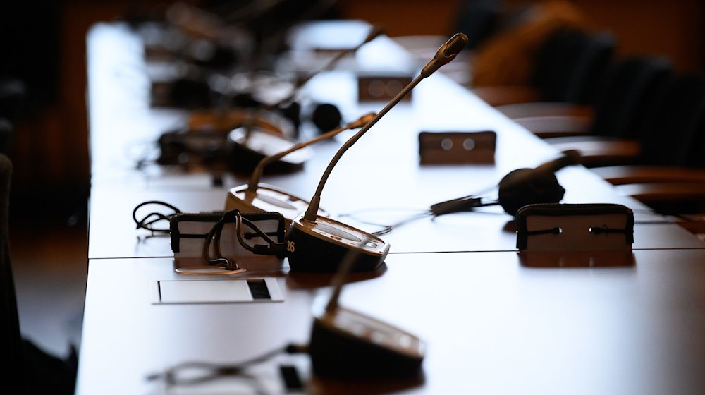 Mikrofone und Kopfhörer auf einem Tisch in einem Gerichtssaal. / Foto: Jonas Walzberg/dpa/Symbolbild