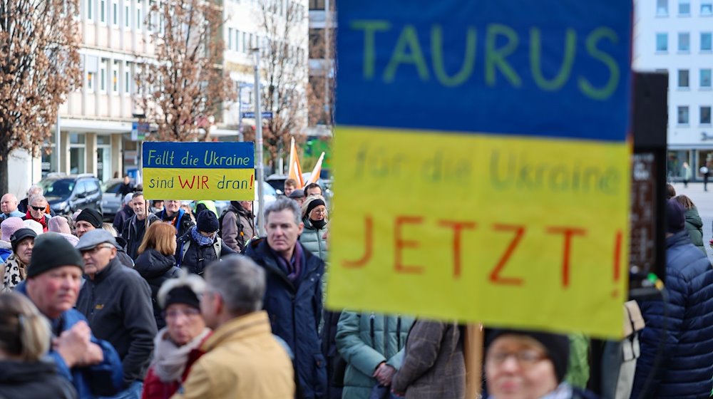 Eine Teilnehmerin fordert bei einer Solidaritätskundgebung für die Ukraine auf dem Kornmarkt auf einem Plakat die Lieferung von Taurus-Marschflugkörpern an die Ukraine. / Foto: Daniel Löb/dpa